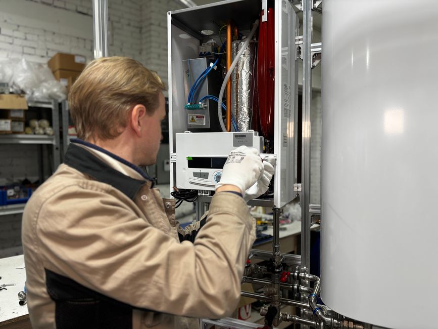 Fontanero revisando un termo eléctrico con una herramienta