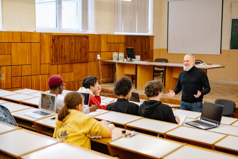 Un grupo pequeño de alumnos trabaja con ordenadores portátiles en una clase.