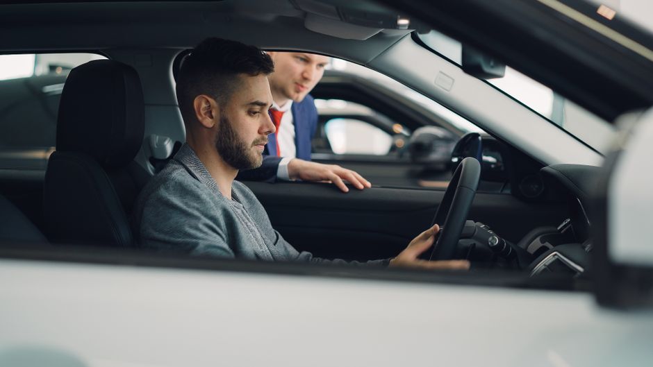 Una persona revisa el interior de un coche antes de comprarlo.