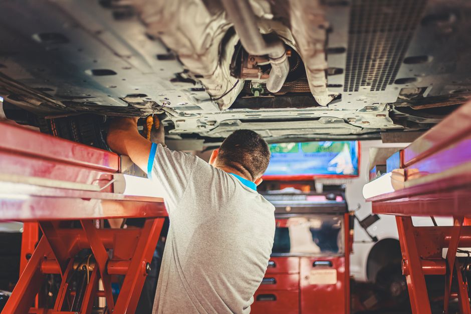 Mecánico revisando un coche de segunda mano con el capó abierto