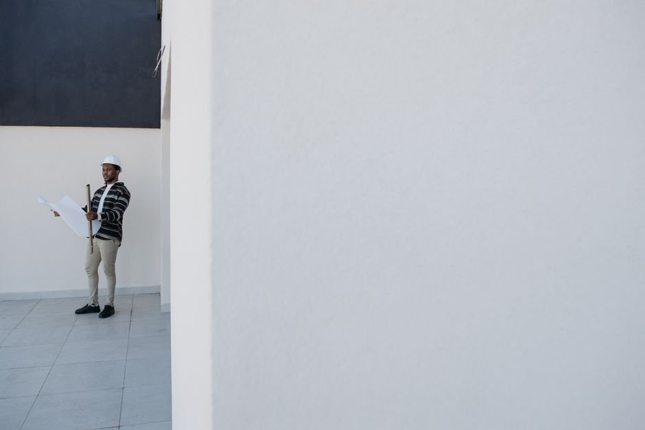 Dos profesionales revisan los planos de una casa sobre la parcela